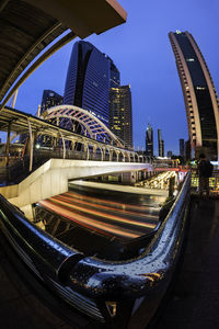 Aerial view of illuminated bridge and buildings against sky