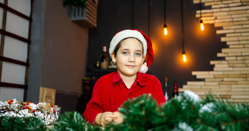 Kid in a xmas cap on a colored background. family christmas shopping