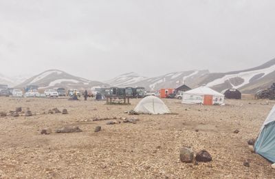 View of tent on arid landscape against sky