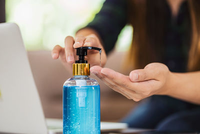 Close-up of woman holding glass bottle