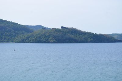 Scenic view of sea and mountains against clear sky