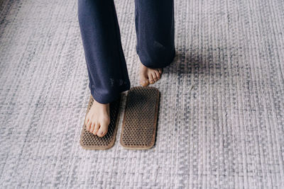 Barefoot female foot stands on a wooden board with nails for concentration practice