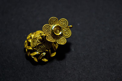 High angle view of yellow flower on table against black background