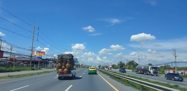 Cars on road against sky in city