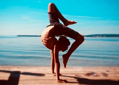 Midsection of woman at beach against sky