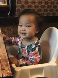 Portrait of cute girl sitting at home