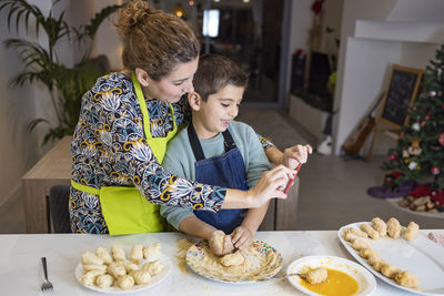 Mother and son making croquettes in the kitchen