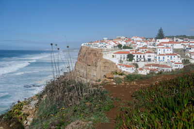 Scenic view of sea against buildings