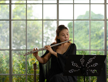 Portrait of musician playing flute in room