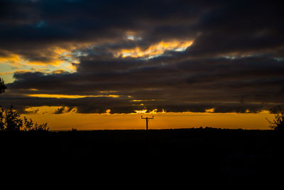 Scenic view of dramatic sky over silhouette land