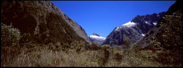 Panoramic view of mountains against clear blue sky