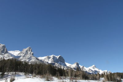 Scenic view of snowcapped mountains against clear blue sky