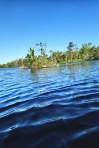 Scenic view of lake against clear blue sky