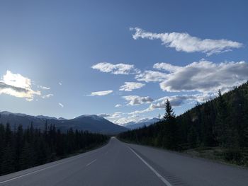 Road amidst trees against sky