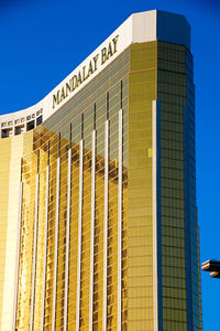 Low angle view of modern building against blue sky