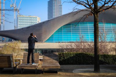 Man with umbrella against trees in city