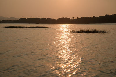 Scenic view of lake against sky during sunset