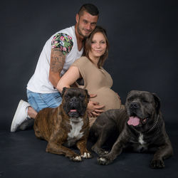 Portrait of a dog sitting against black background