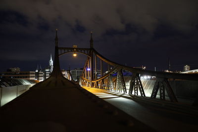 Bridge over illuminated ulm and it's cathedral against sky at night