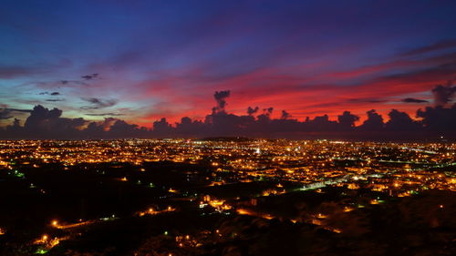 Aerial view of illuminated city against sky at sunset