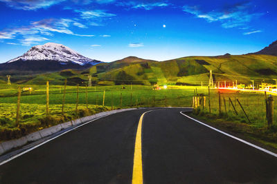 Empty road by mountain against sky