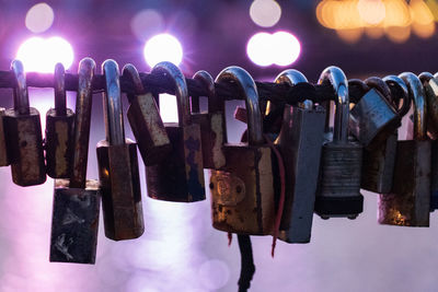 Close-up of padlocks hanging on metal against sky