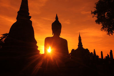 Silhouette statue of temple during sunset