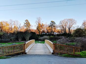 Footbridge amidst plants against sky