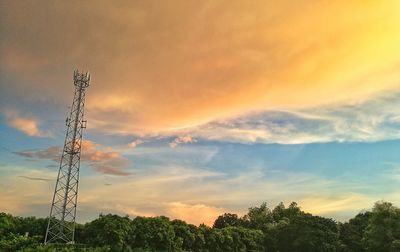 Low angle view of electricity pylon against sky during sunset