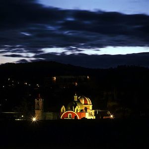 View of illuminated buildings against cloudy sky