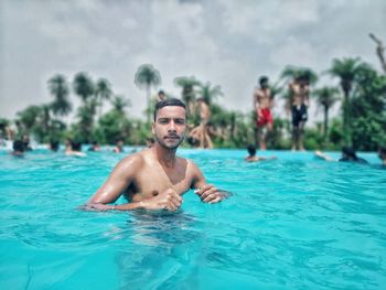 Portrait of shirtless man swimming in pool