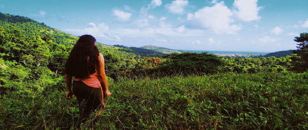 Rear view of woman standing on land against sky