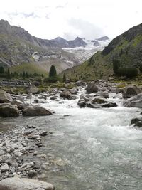Scenic view of river and mountains against sky