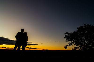 Silhouette men standing against clear sky during sunset