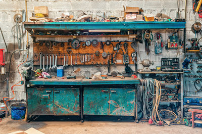 Vintage workshop. antique tools hang on the wall, repair equipment on the table. front view