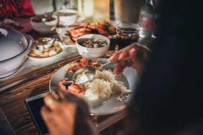 Midsection of person eating food on dining table