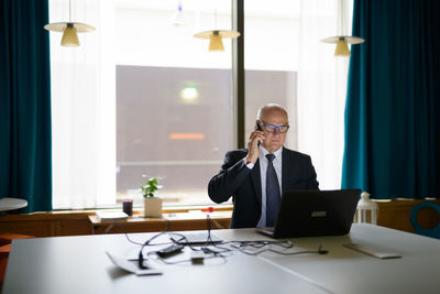 Man using phone while sitting on table