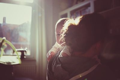 Close-up of mother carrying baby girl at home