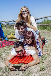 Young boys and girls in campsite piled up smiling