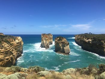 Scenic view of rocks in sea against blue sky