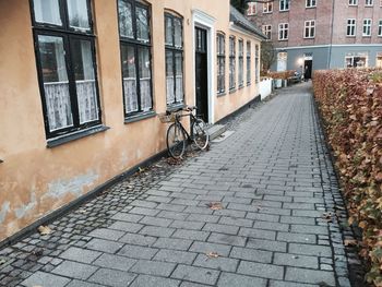 Bicycle parked on walkway by house