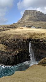 Scenic view of waterfall against sky