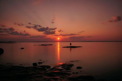 Scenic view of sea against romantic sky at sunset