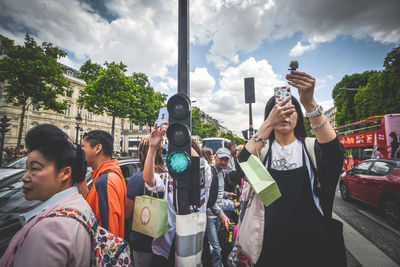 People standing on street in city against sky