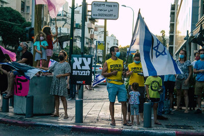 Group of people on road against buildings