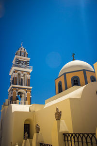 Low angle view of bell tower against blue sky