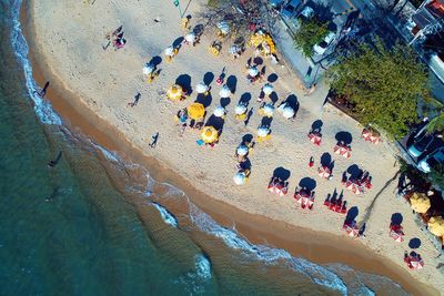 Aerial view of people and beach umbrellas at coastline