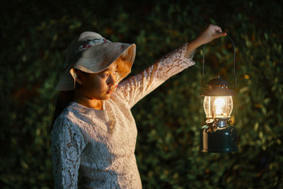 Side view of man holding lit candle