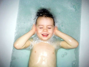 Portrait of happy girl in bathtub