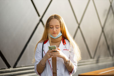 Doctor wearing mask using phone